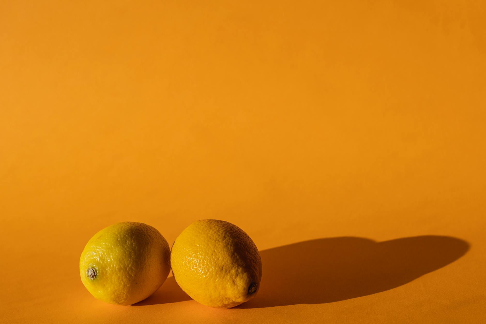 Limones frescos en una composición vibrante sobre un fondo amarillo en una sesión fotográfica profesional